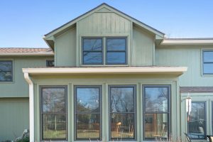A row of fiberglass windows on the back side of a green home.