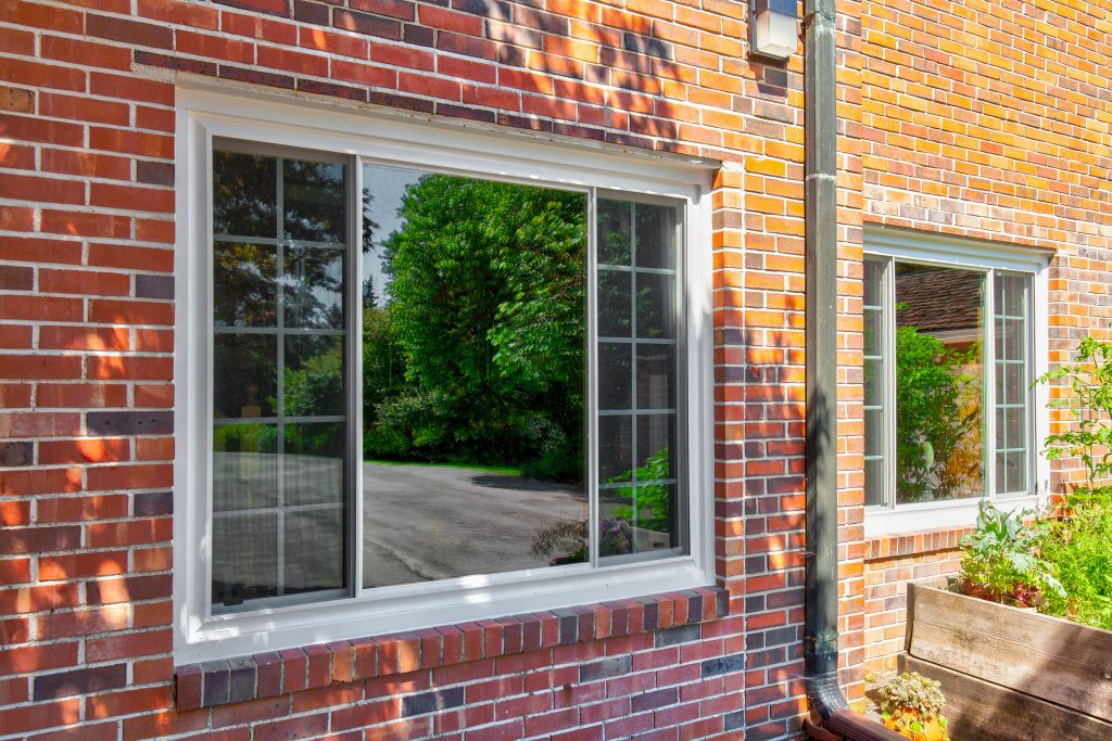 Slider window from the outside. The window is closed and surrounded by brick walls.